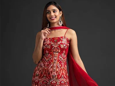 Woman wearing red and gold embroidered traditional ethnic dress with matching red dupatta